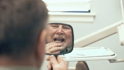 patient taking a look at their new all-on-4 dental implants in the mirror